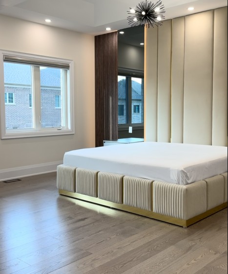 Channel-upholstered bed with integrated lighting and mirrored wall detail